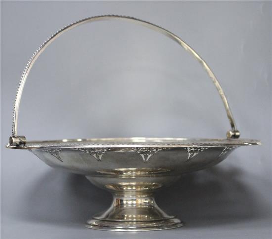 A Victorian engraved and pierced silver circular pedestal dish with swing handle, B.B, Sheffield, 1865,